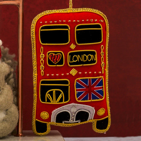 Decorative red london bus front ornament with gold accents on a red background