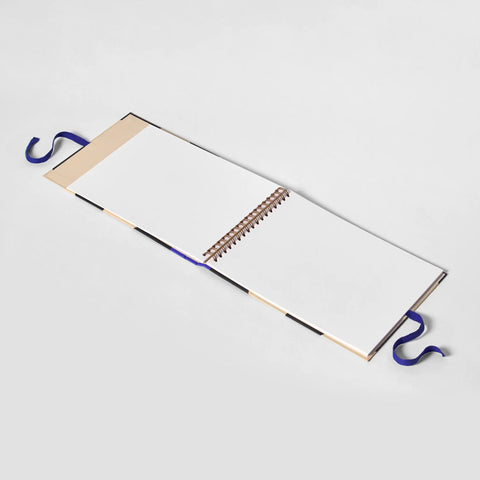 Ring-bound sketchbook with blue ribbon fastening.