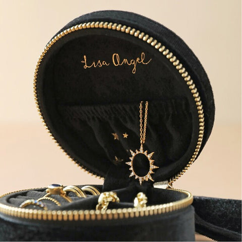Black jewelry box with gold accents containing a necklace and rings, branded 'Lisa Angel'.