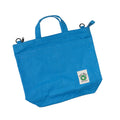 Blue tote bag with a visible brand label on a white background