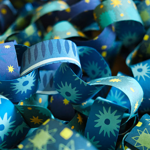 Close-up of blue paper chain rings with star and moon patterns