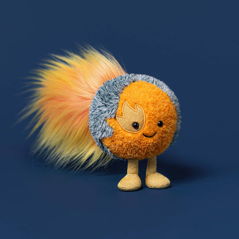 orange and grey plush toy with an embroidered flame motif and gold sparkly legs on a navy background