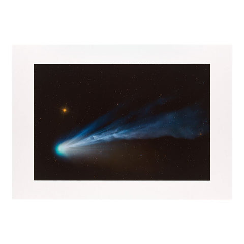 Comet with a bright tail against a starry night sky