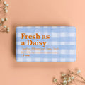 Bar of soap with 'Fresh as a Daisy' text on a checkered background