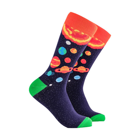 A pair of crew socks with a space theme, featuring a dark navy blue starry background with colorful planets and Saturn, bright orange cuffs, and green toes and heels
