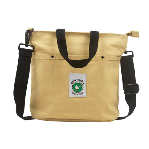 Beige bag with black straps and a visible brand label on 