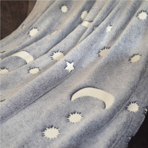 Grey fleece throw with white moon and stars design.