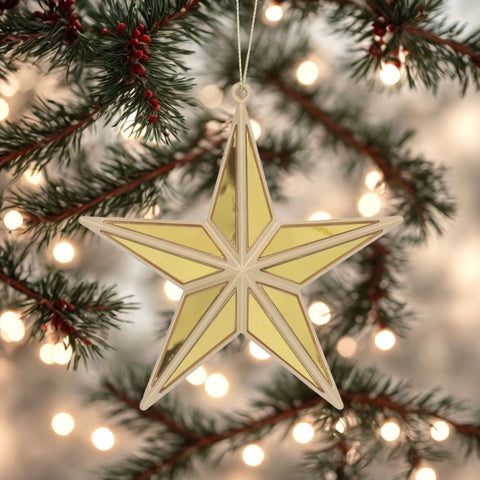 Decorative gold star ornament hanging on a Christmas tree with lights in the background