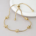 Gold bracelet with star-shaped charms on a light gray background