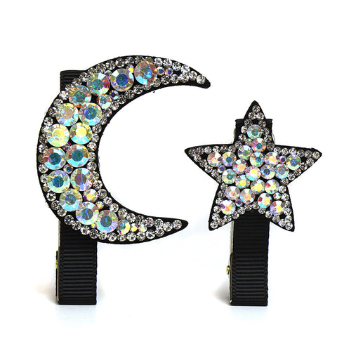 Black hair clips with moon and star shapes decorated with gemstones.