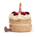 Plush toy birthday cake with a candle and strawberries on the top