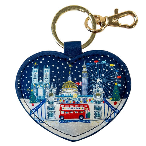 Heart-shaped keychain with London-themed design featuring Big Ben, a red bus, and Christmas trees on a blue background.