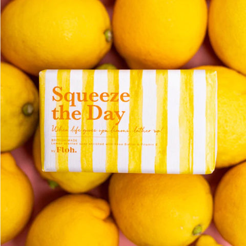 'Squeeze the Day' lemon soap bar sitting on fresh lemons