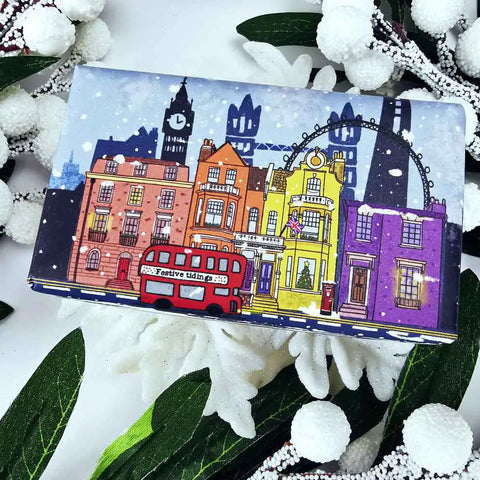 Bar of soap with a colorful cityscape design wrapper on a Christmas decorative background