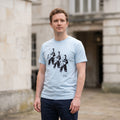 man wearing a sky blue t-shirt with three astronauts printed on the front