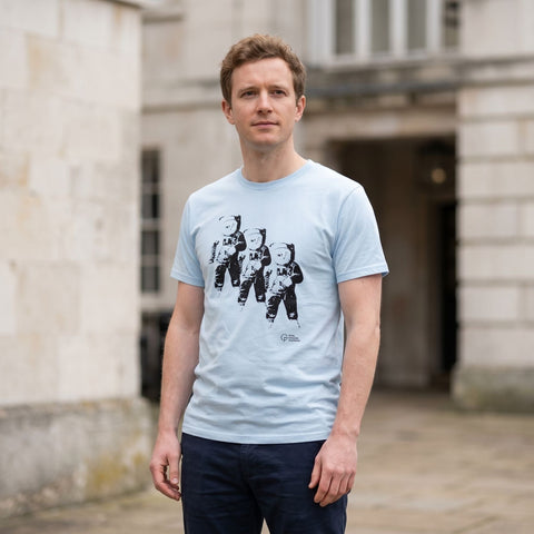 man wearing a sky blue t-shirt with three astronauts printed on the front