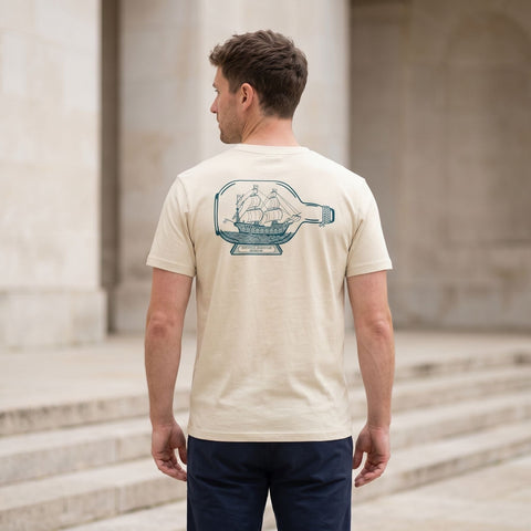 man wearing a t-shirt with a printed ship in bottle design on the back