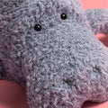 Close-up of a grey manatee plush toy with black eyes 