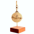 Gold astrolabe on a wooden stand back view showing months, numbers and star-sign symbols