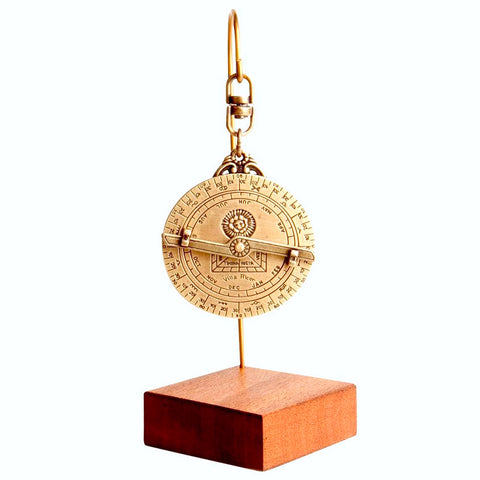 Gold astrolabe on a wooden stand back view showing months, numbers and star-sign symbols