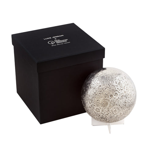 Silver moon-shaped object with a black box 