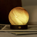 Round lamp with a warm glow on a surface