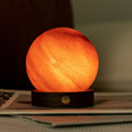 Round orange lamp on a surface with a dark background