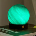 Green glowing sphere on a book with a blurred background