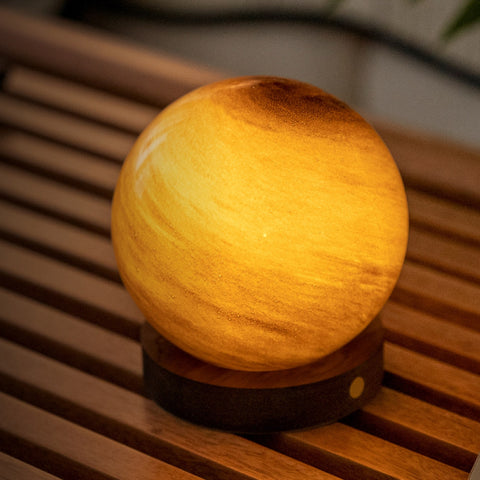 Glass ball lamp with a warm glow on a wooden surface