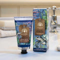 Hand cream and packaging with ocean-themed design on a bathroom counter.