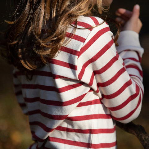 Child wearing a red and white striped top.