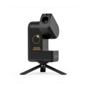 A black solar eclipse tracker camera on a small tripod stand, featuring gold text and a sun graphic on its body, set against a plain white background.