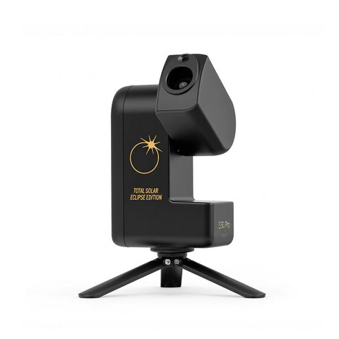 A black solar eclipse tracker camera on a small tripod stand, featuring gold text and a sun graphic on its body, set against a plain white background.