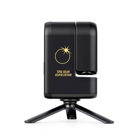 A black solar eclipse monitor smart telescope on a small tripod stand, featuring a gold sun and eclipse graphic with the text 'TOTAL SOLAR ECLIPSE EDITION' on the side.