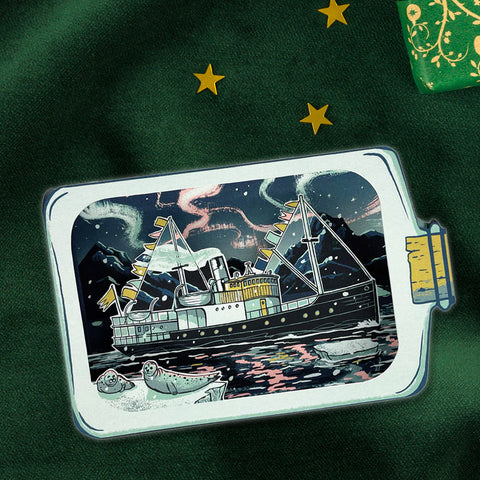 ship in a bottle design greeting card on a dark background with stars, on a green fabric surface.