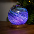 Glowing purple crystal ball on a wooden base 