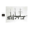 black and white photograph of The Endurance ship trapped in the snow and ice, with men and dogs in the foreground