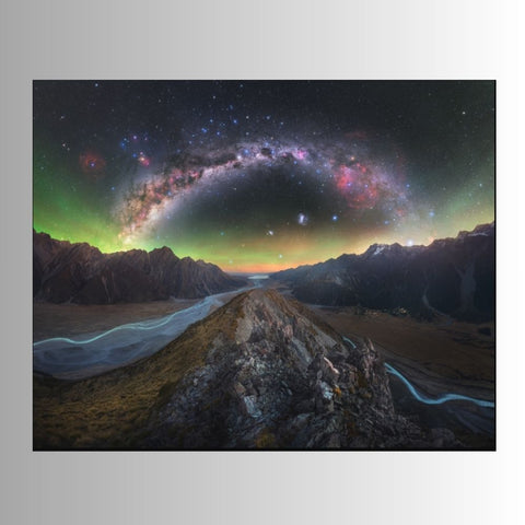 Astronomical landscape with a river, mountains, and a starry sky with the Milky Way.
