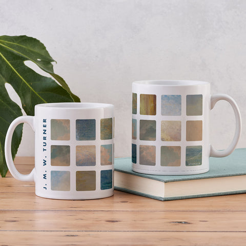 Two mugs with a grid pattern on a wooden surface with a plant in the background