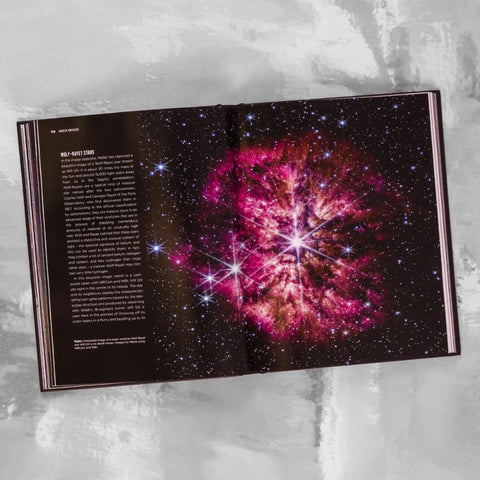 Open book showing an image of a colourfull nebula 