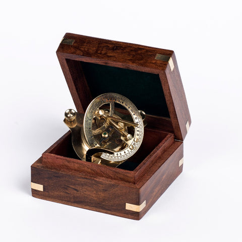 Detailed antique-style brass sundial in a wooden box.