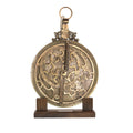 Brass astrolabe on a wooden stand.