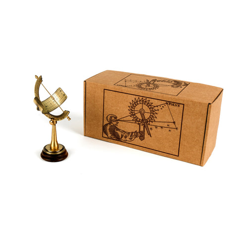 Equatorial sundial on wooden base next to box with renaissance style illustration.