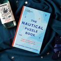 The National Maritime Museum Nautical Puzzle Book on a fabric background.