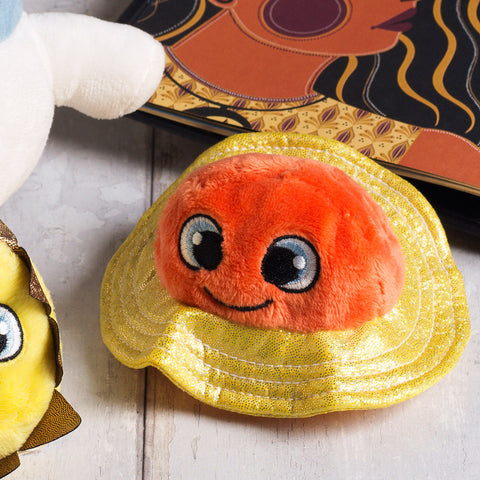 Orange plush toy planet Saturn with a smiley embroidered face and glittery gold fabric rings.