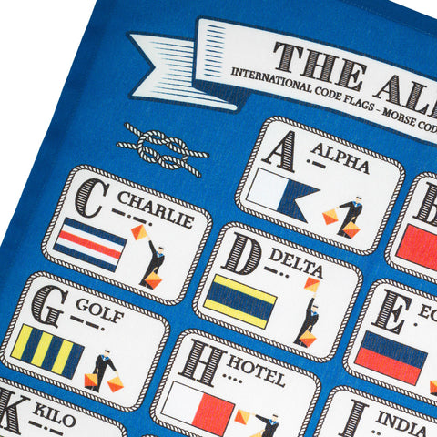 Close-up of blue tea towel featuring an illustrated alphabet in different codes.