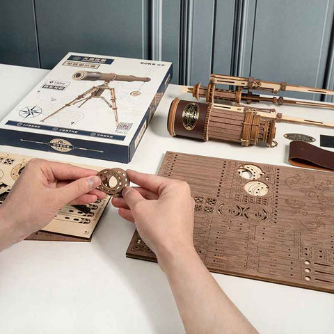 A person assembling the wooden telescope kite.